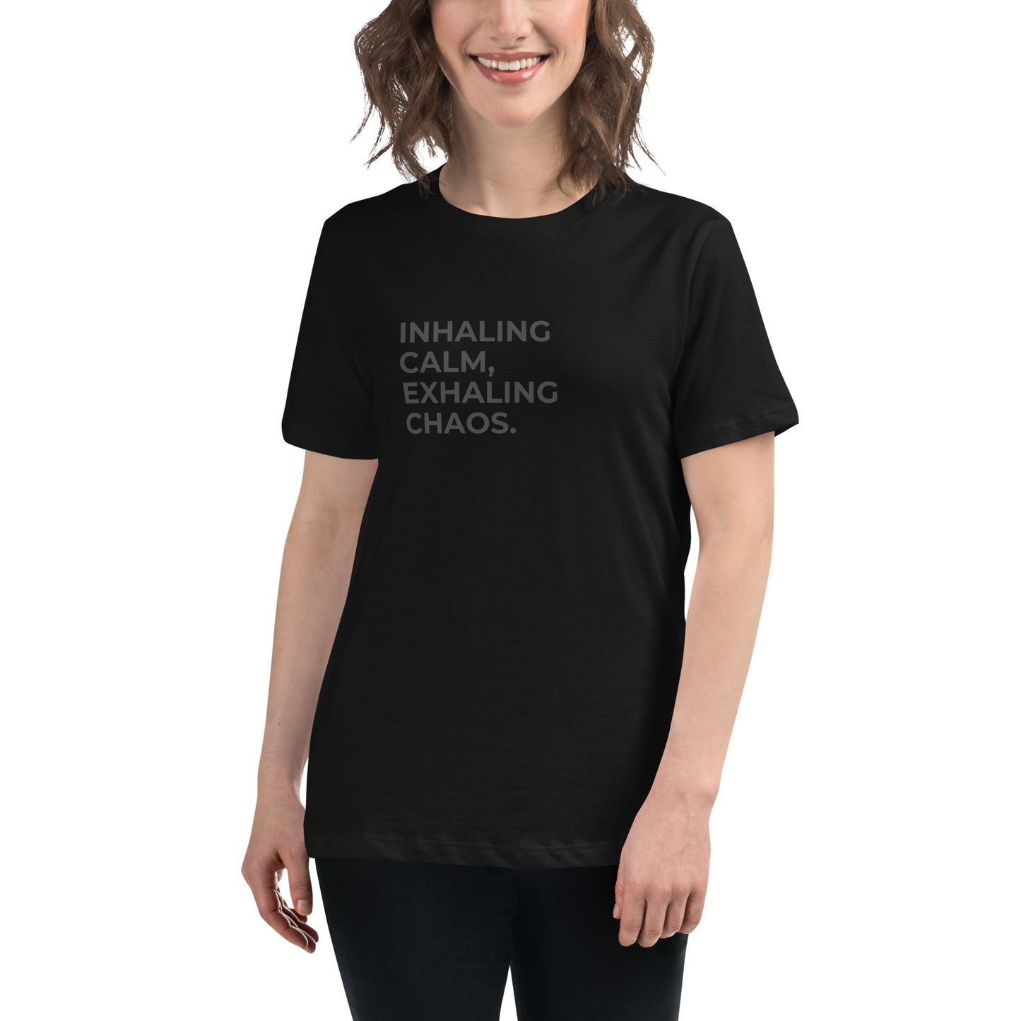 Woman wearing a black relaxed tee with "Inhaling Calm, Exhaling Chaos" printed.