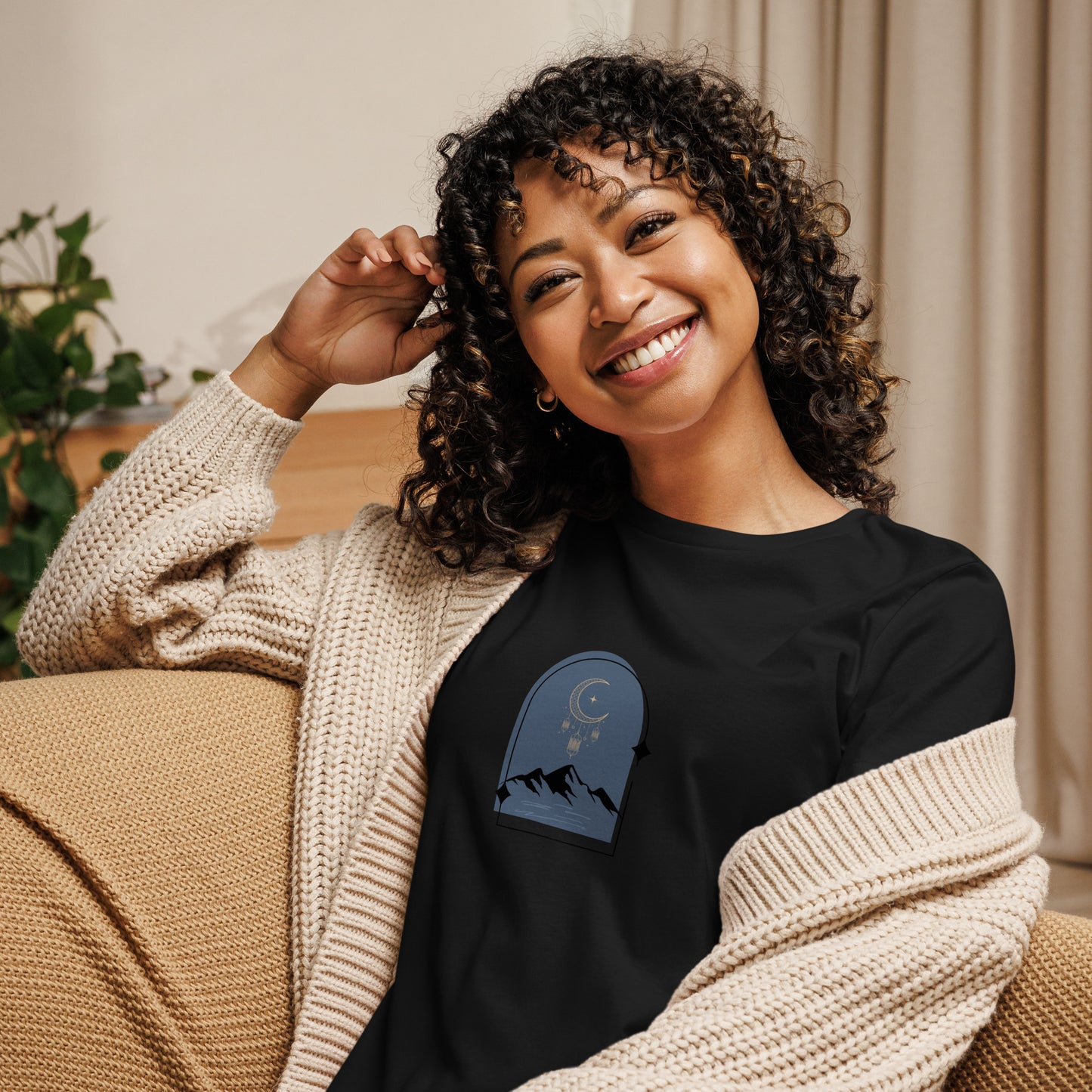 Woman wearing a black relaxed tee with a tranquil night sky graphic design, representing comfortable and authentic fashion by BYOL.