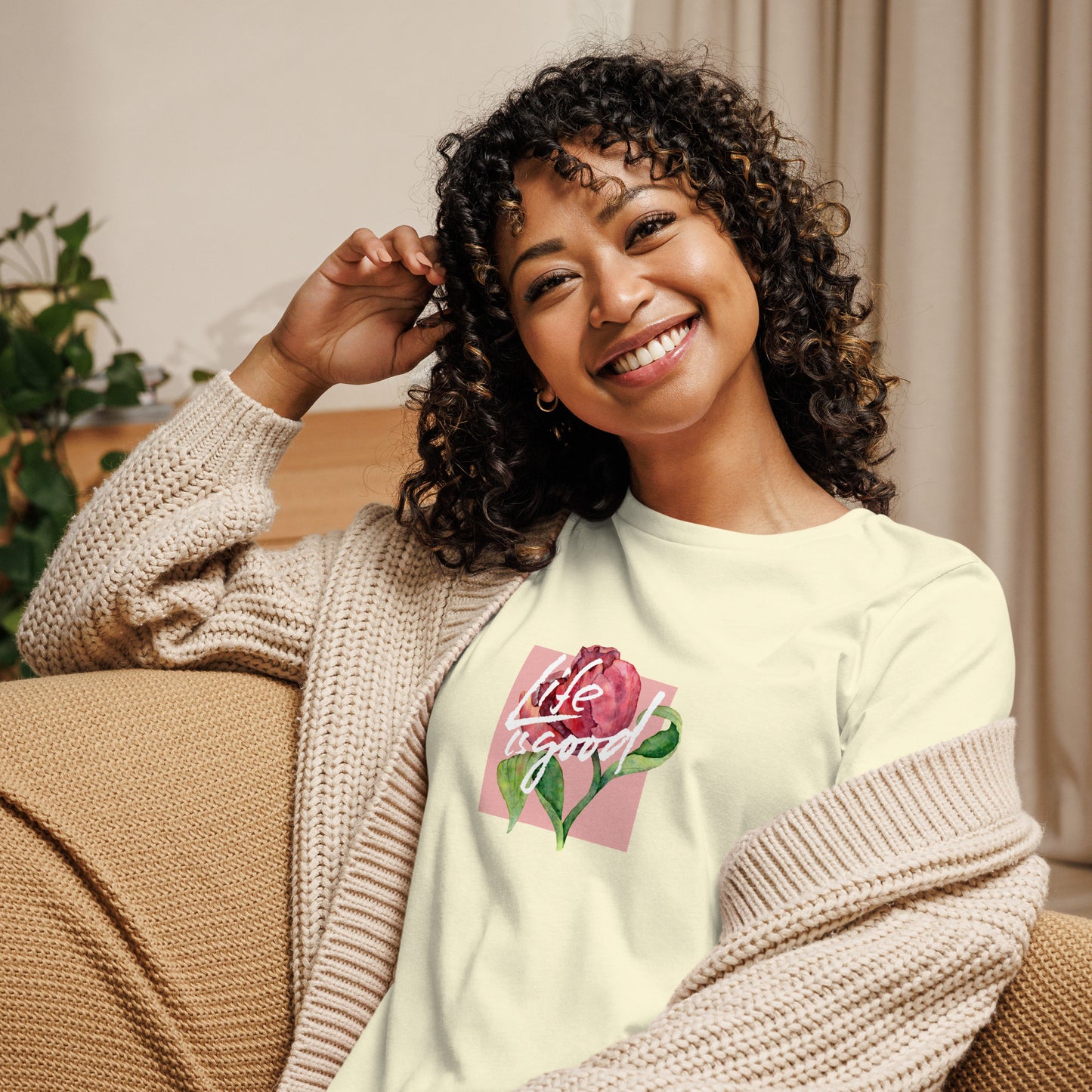 Woman smiling in a citron relaxed t-shirt with colorful 'Life in Bloom' floral design