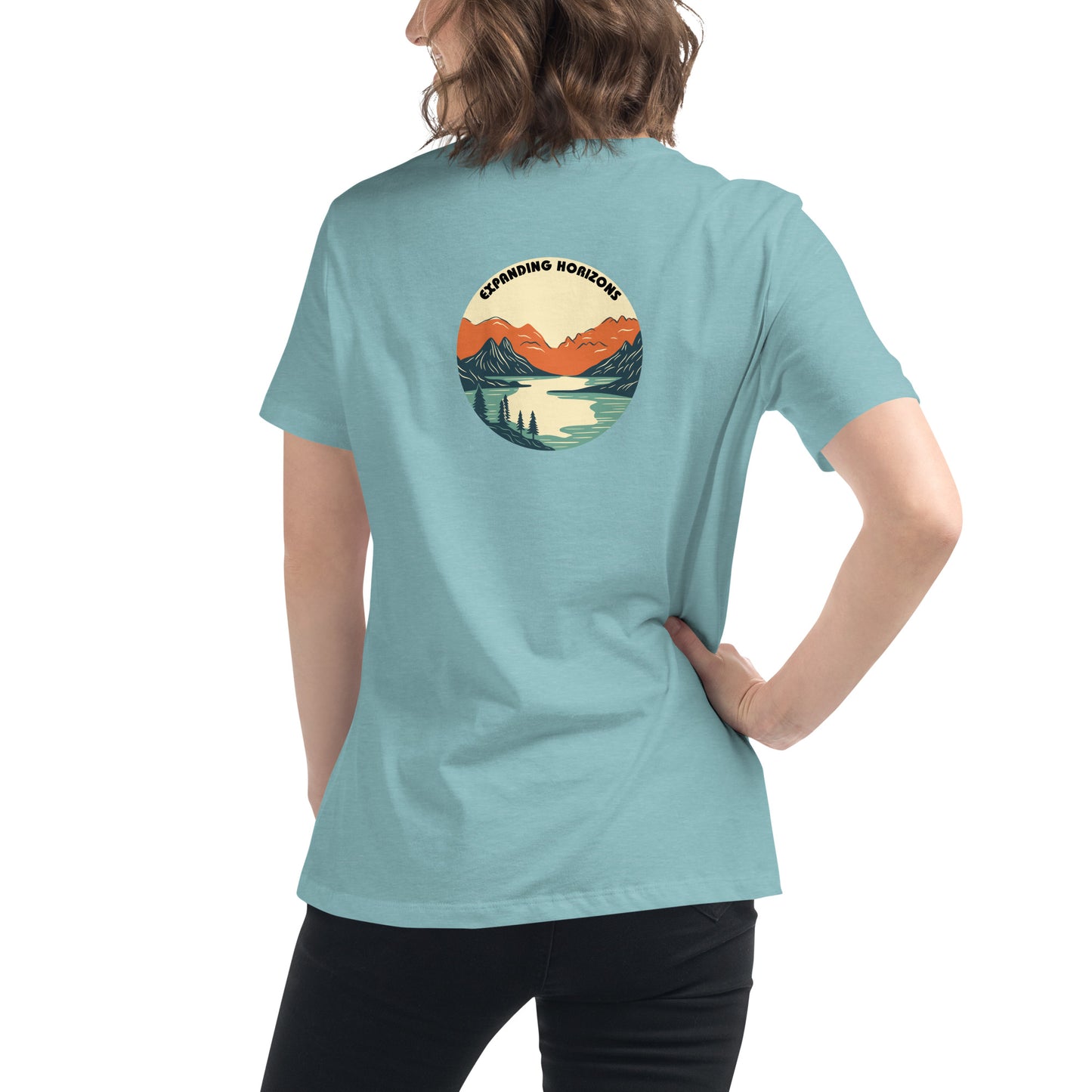 Woman wearing a heather blue relaxed t-shirt featuring a scenic mountain and lake design with 'Expanding Horizons' text