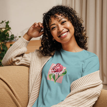 Woman smiling in a heather blue relaxed t-shirt with colorful 'Life in Bloom' floral design