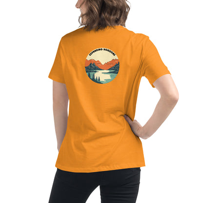 Woman wearing a heather orange relaxed t-shirt featuring a scenic mountain and lake design with 'Expanding Horizons' text