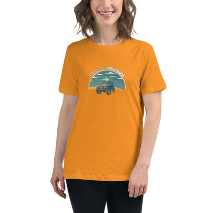 Woman smiling in a heather orange relaxed t-shirt with 'Aim for the Adventure' and a vintage camper graphic