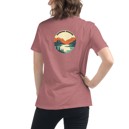 Woman wearing a heather mauve relaxed t-shirt featuring a scenic mountain and lake design with 'Expanding Horizons' text