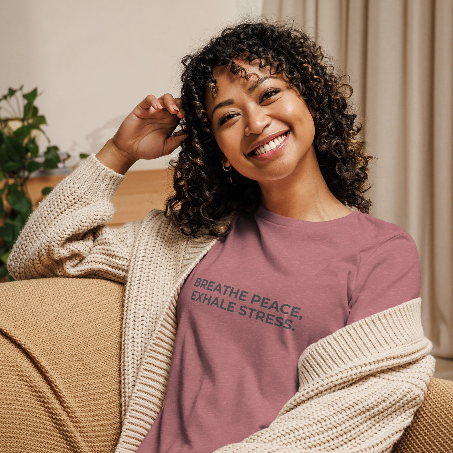 Woman wearing a heather mauve relaxed tee with "Breathe Peace, Exhale Stress" printed.