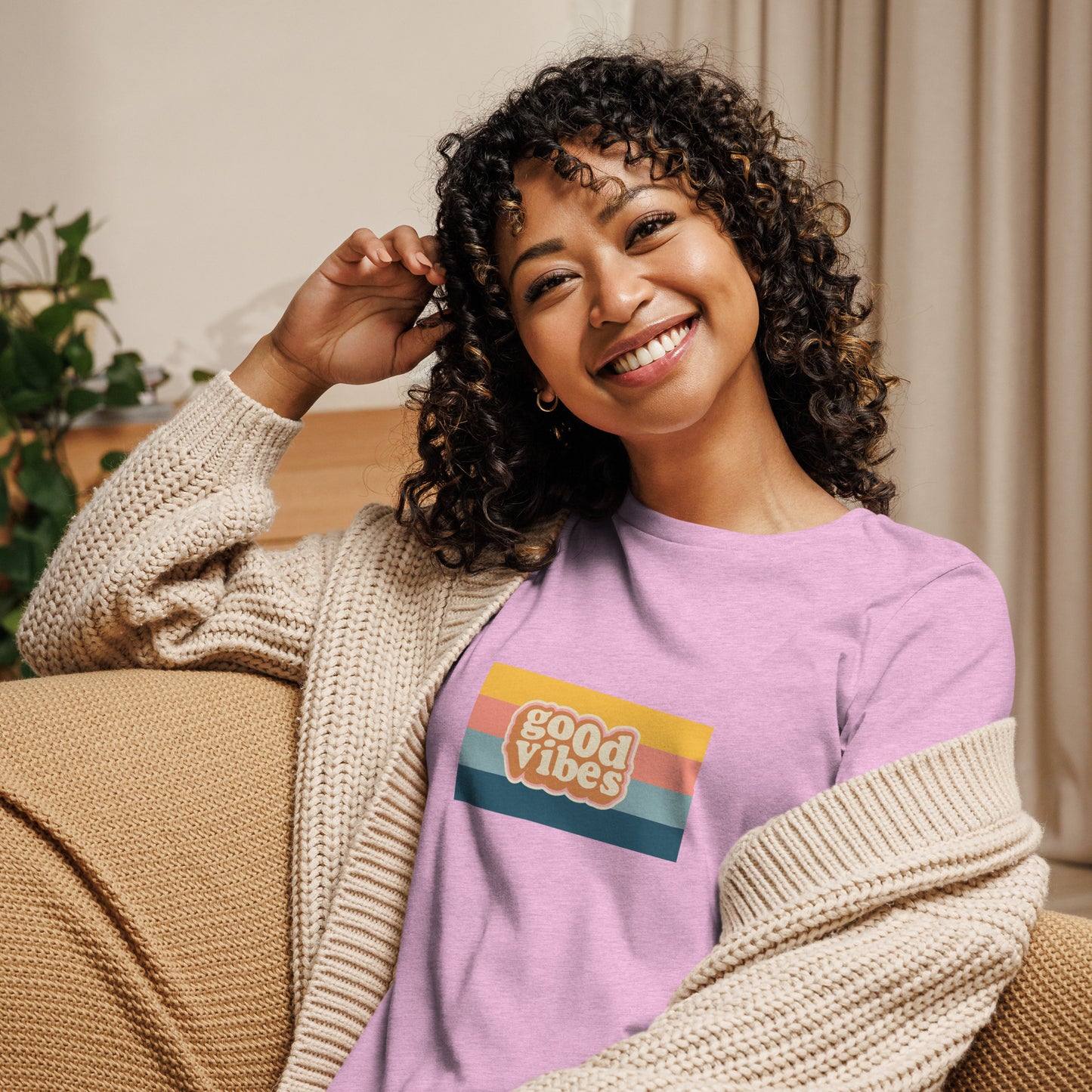 Woman smiling in a heather lilac relaxed t-shirt with colorful 'Good Vibes' graphic