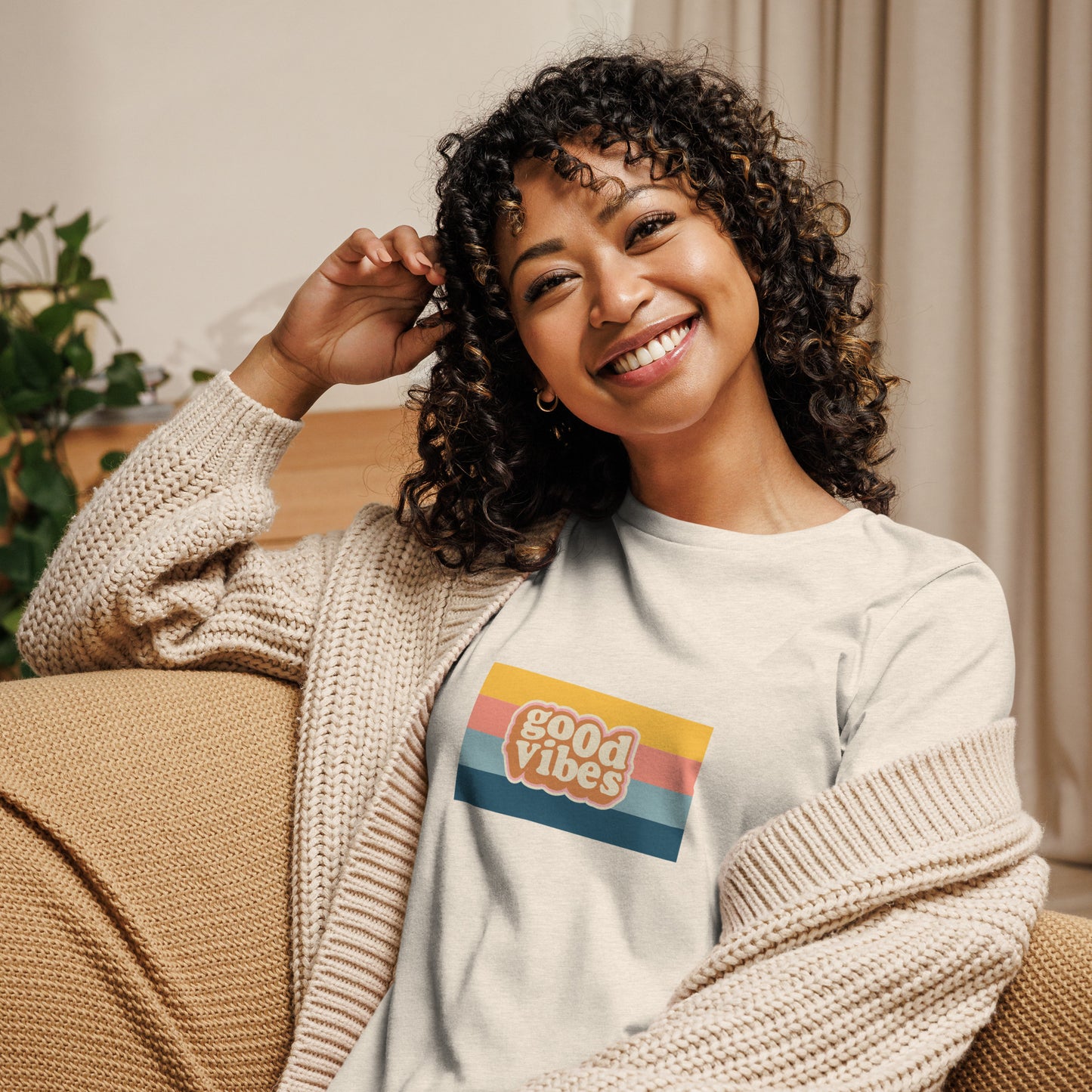 Woman smiling in a citron relaxed t-shirt with colorful 'Good Vibes' graphic