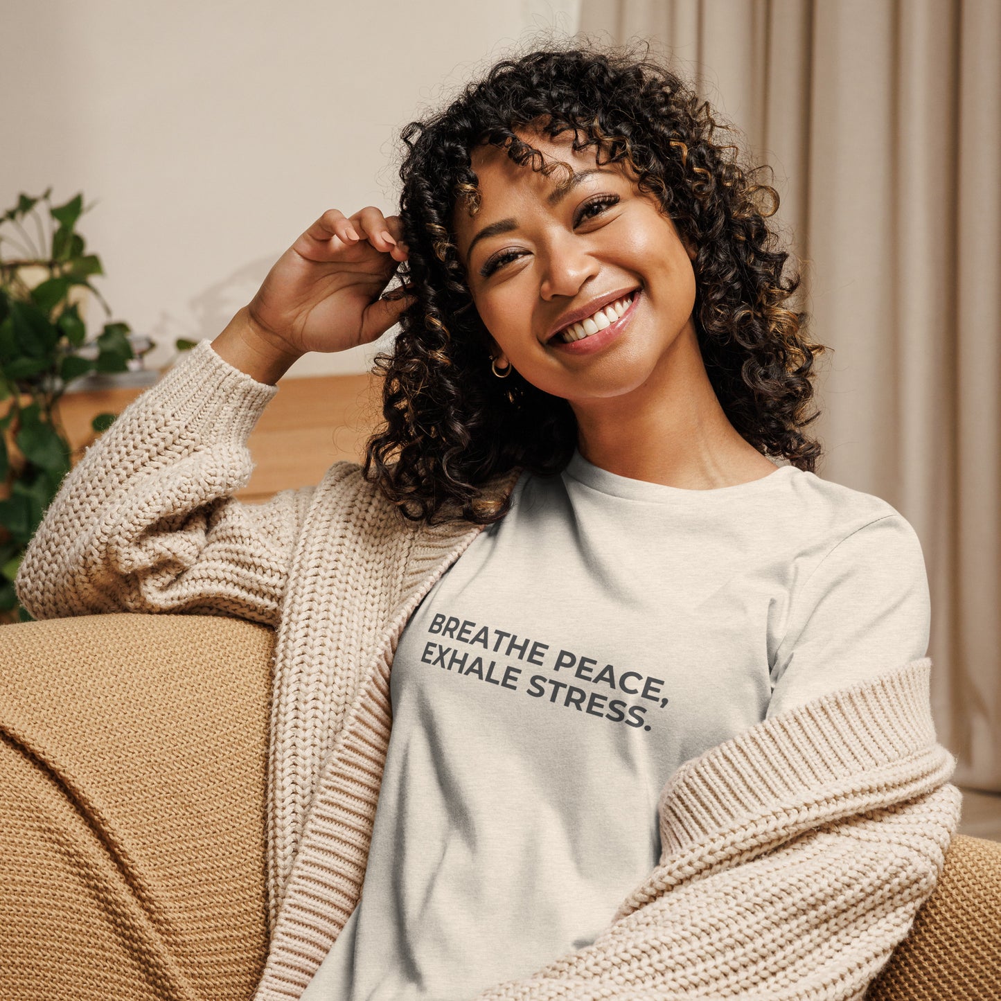 Woman wearing a natural relaxed tee with "Breathe Peace, Exhale Stress" printed.