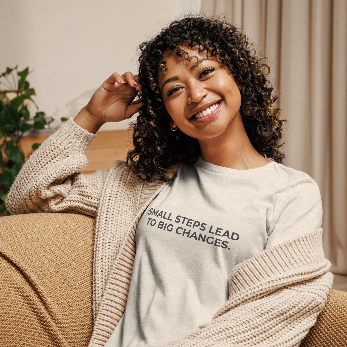 Woman wearing an stone relaxed tee with "Small Steps Lead to Big Changes" printed.