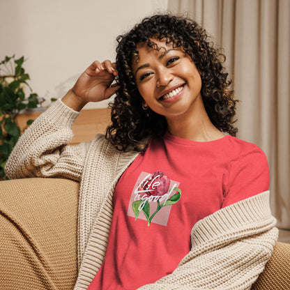 Woman smiling in a heather red relaxed t-shirt with colorful 'Life in Bloom' floral design