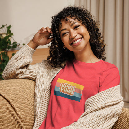 Woman smiling in a poppy red relaxed t-shirt with colorful 'Good Vibes' graphic