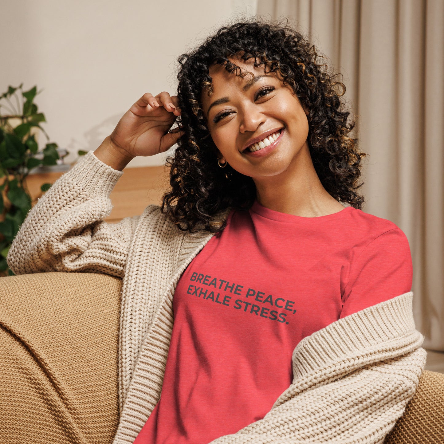 Woman wearing a heather red relaxed tee with "Breathe Peace, Exhale Stress" printed.