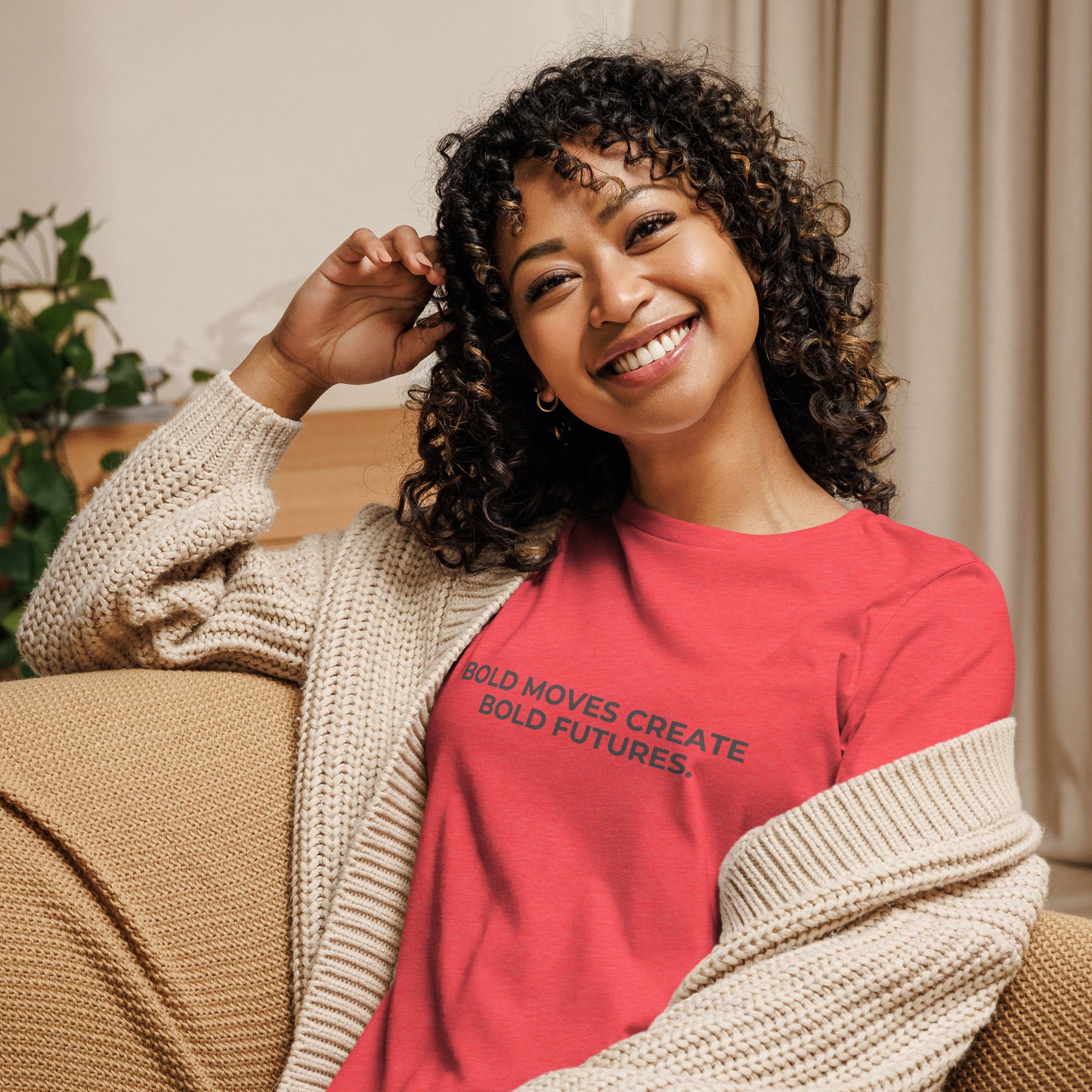 Woman wearing a heather red relaxed tee with "Bold Moves Create Bold Futures" printed.