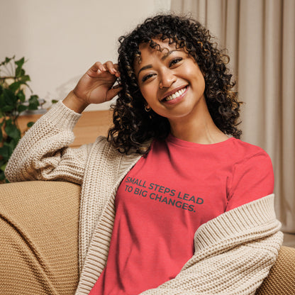 Woman wearing an heather red relaxed tee with "Small Steps Lead to Big Changes" printed.