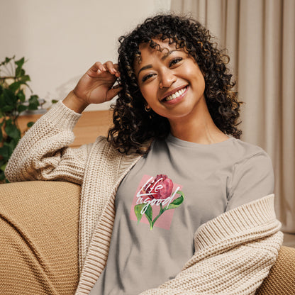 Woman smiling in a heather stone relaxed t-shirt with colorful 'Life in Bloom' floral design