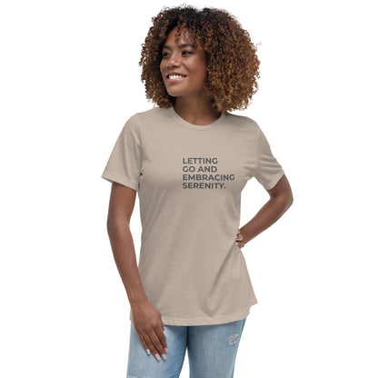 Woman wearing a stone relaxed tee with "Letting Go and Embracing Serenity" printed, available in various colors and sizes from S-3XL.