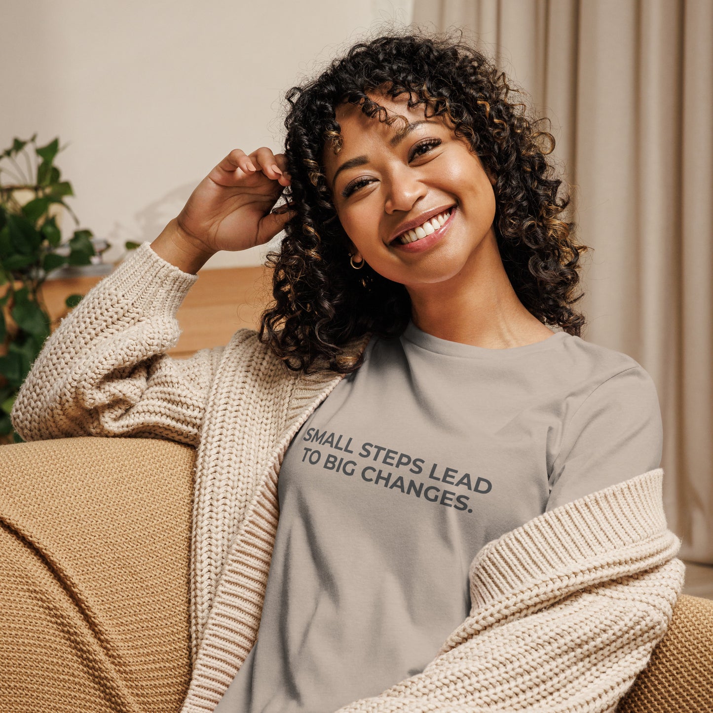 Woman wearing an stone relaxed tee with "Small Steps Lead to Big Changes" printed.