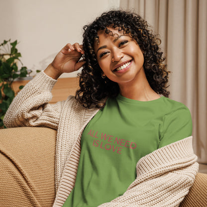 Woman smiling in leaf green relaxed t-shirt with 'All We Need Is Love' phrase