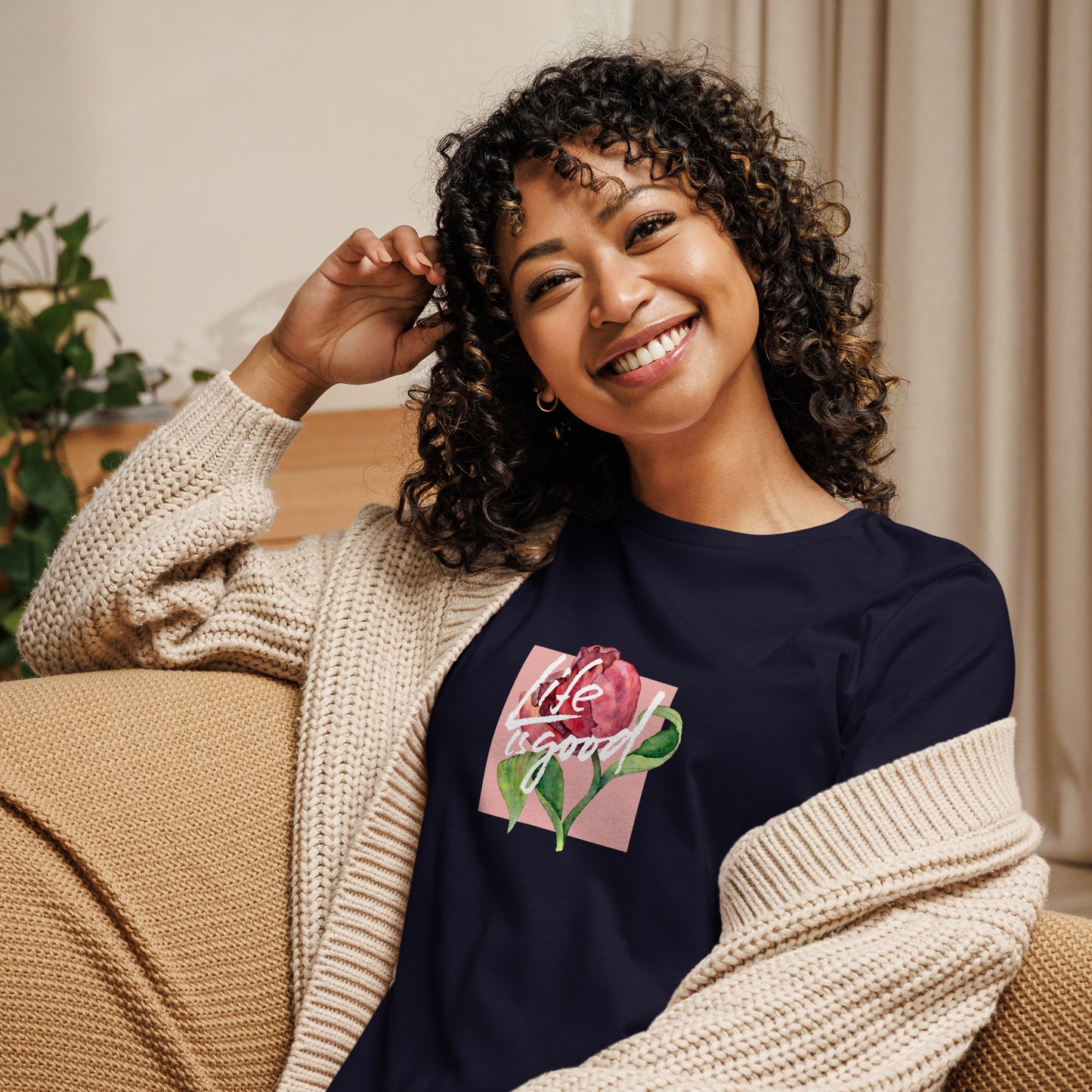 Woman smiling in a navy blue relaxed t-shirt with colorful 'Life in Bloom' floral design