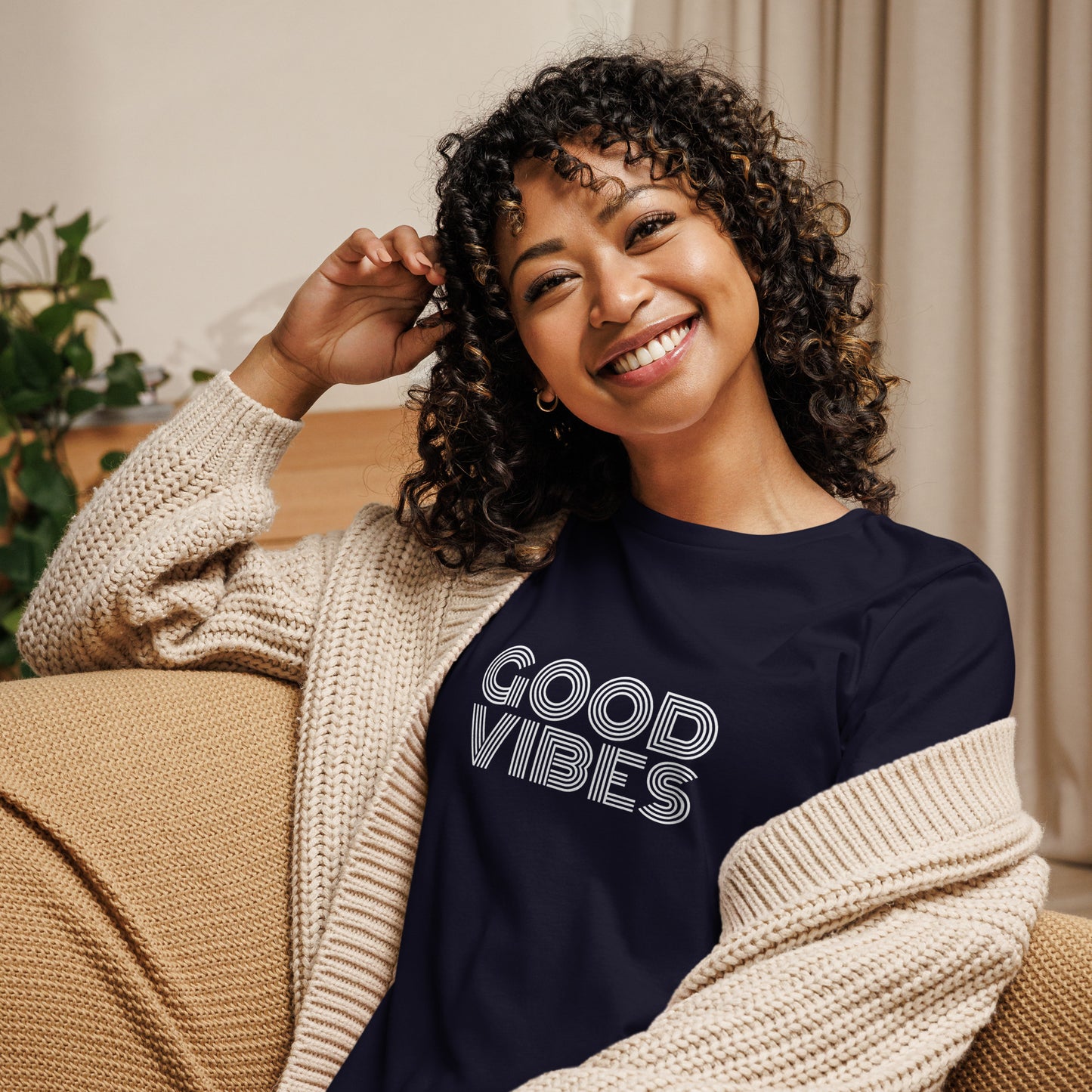 Woman smiling in a navy relaxed t-shirt with "Good Vibes" in white lettering, promoting a positive and cheerful style.