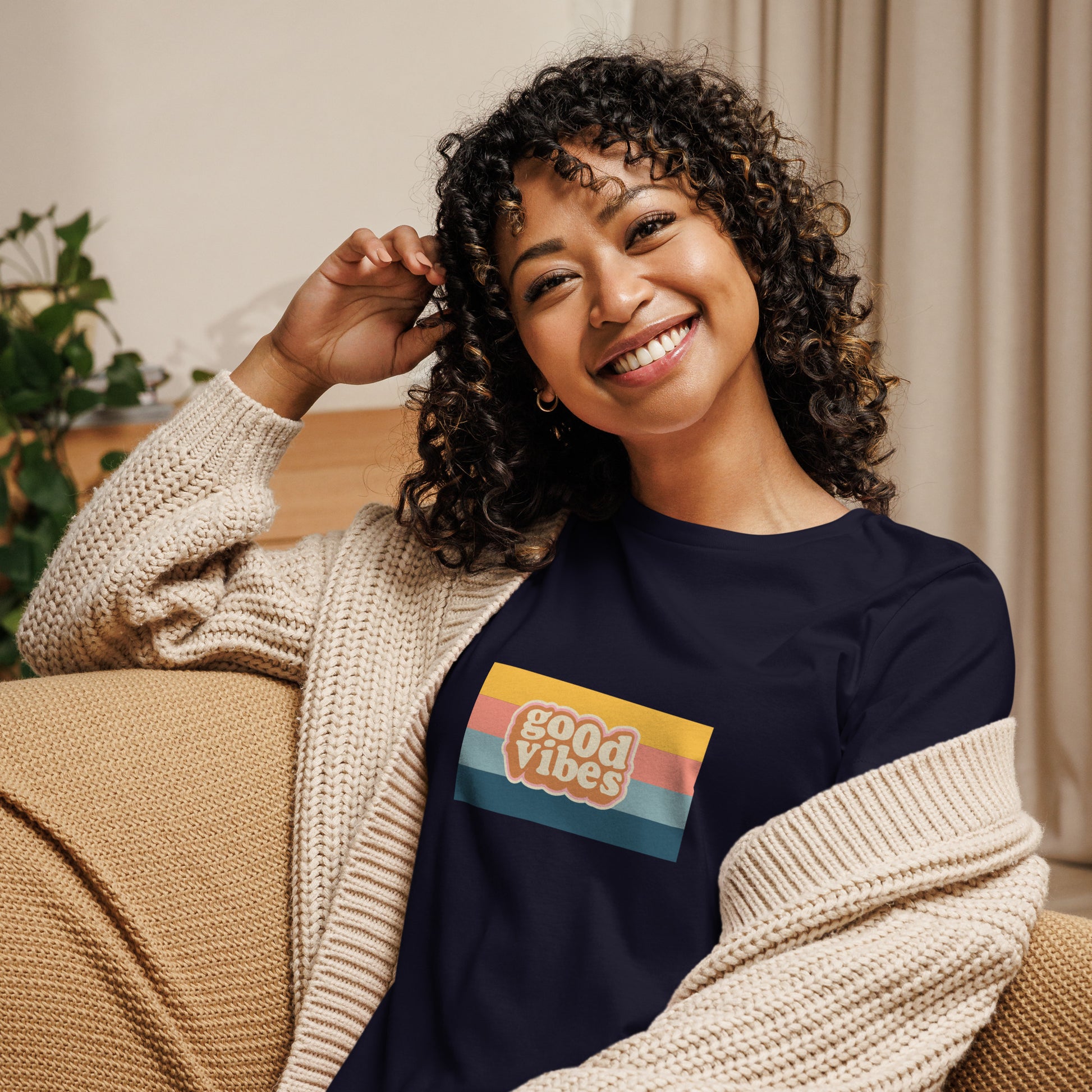 Woman smiling in a navy blue relaxed t-shirt with colorful 'Good Vibes' graphic