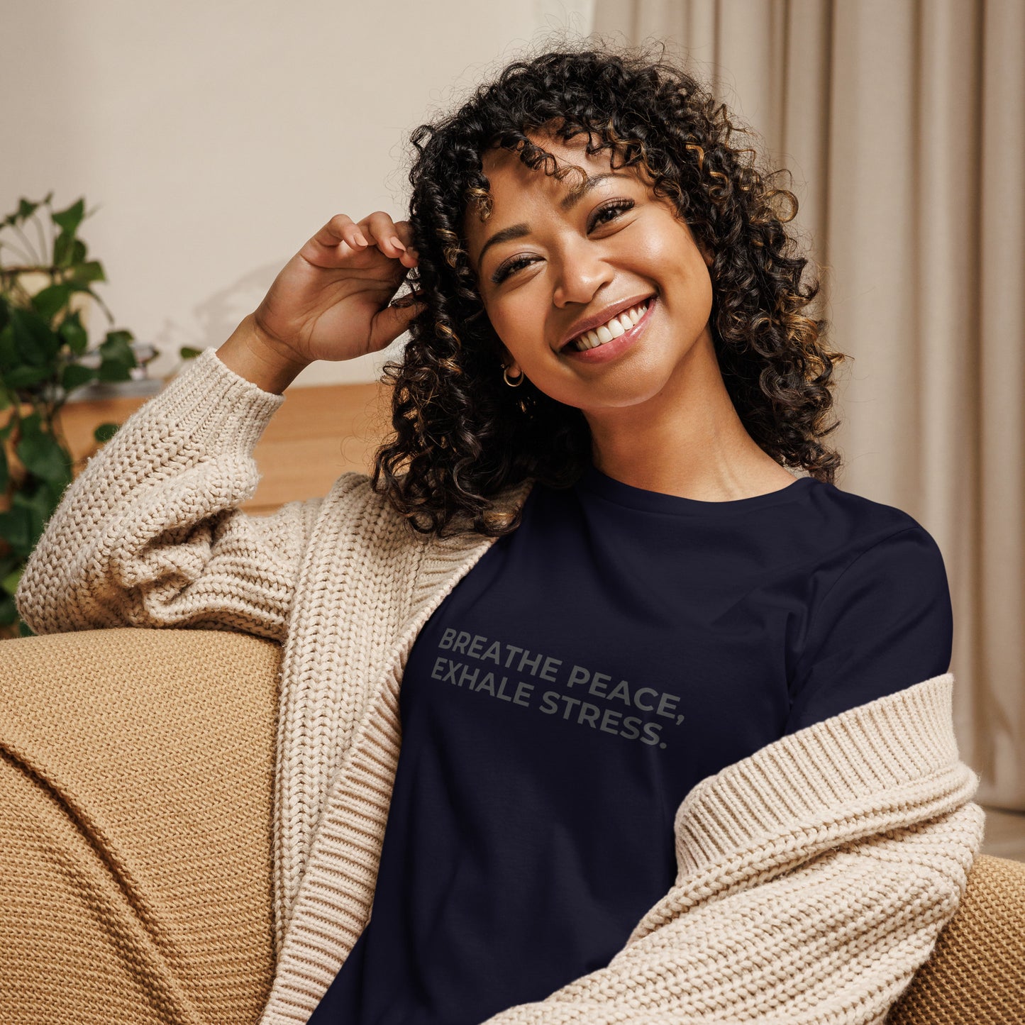 Woman wearing a navy relaxed tee with "Breathe Peace, Exhale Stress" printed.