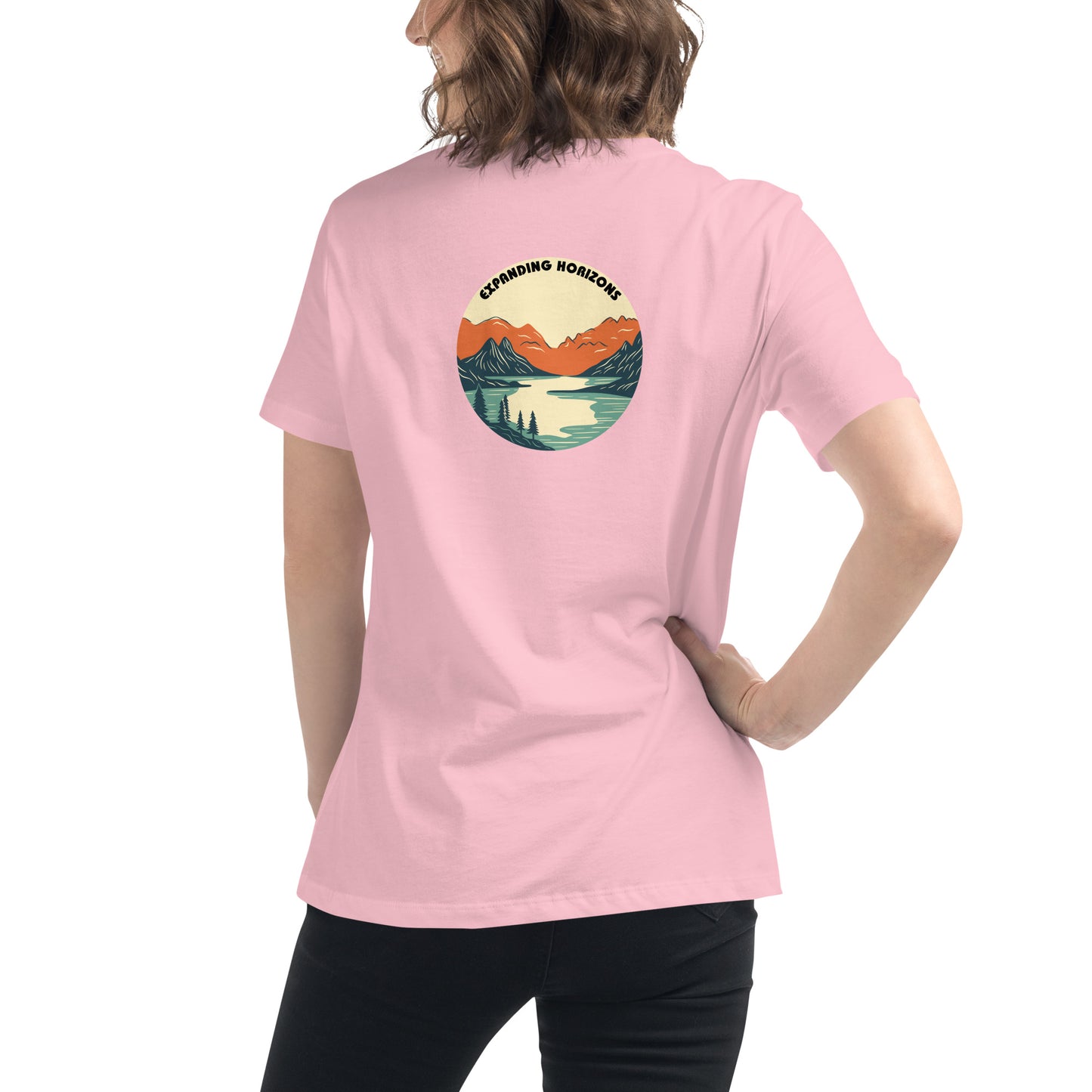 Woman wearing a pink relaxed t-shirt featuring a scenic mountain and lake design with 'Expanding Horizons' text