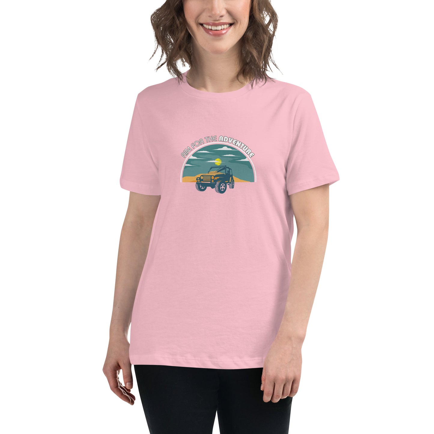 Woman smiling in a pink relaxed t-shirt with 'Aim for the Adventure' and a vintage camper graphic