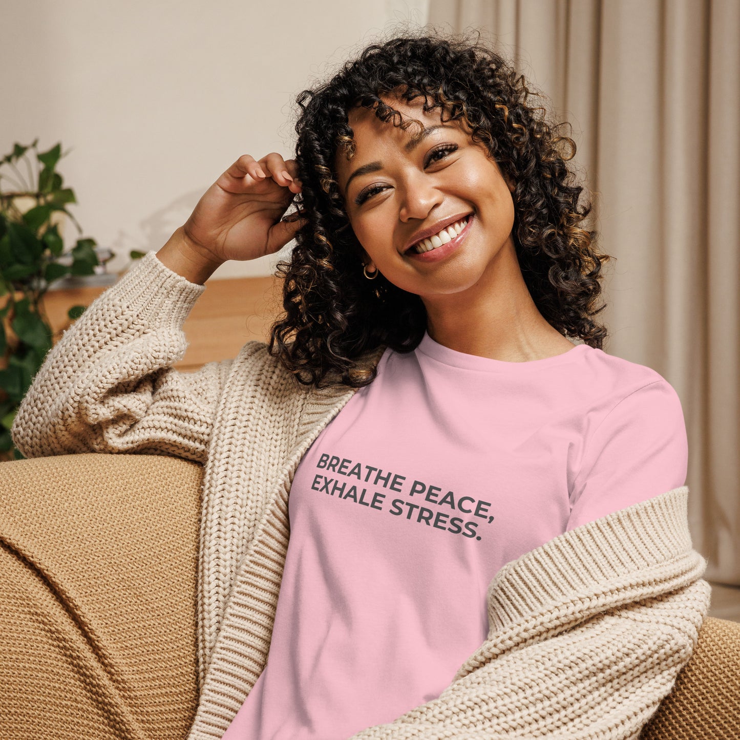 Woman wearing a pink relaxed tee with "Breathe Peace, Exhale Stress" printed.