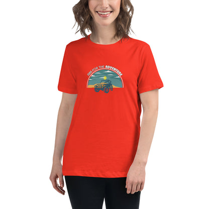 Woman smiling in a poppy red relaxed t-shirt with 'Aim for the Adventure' and a vintage camper graphic