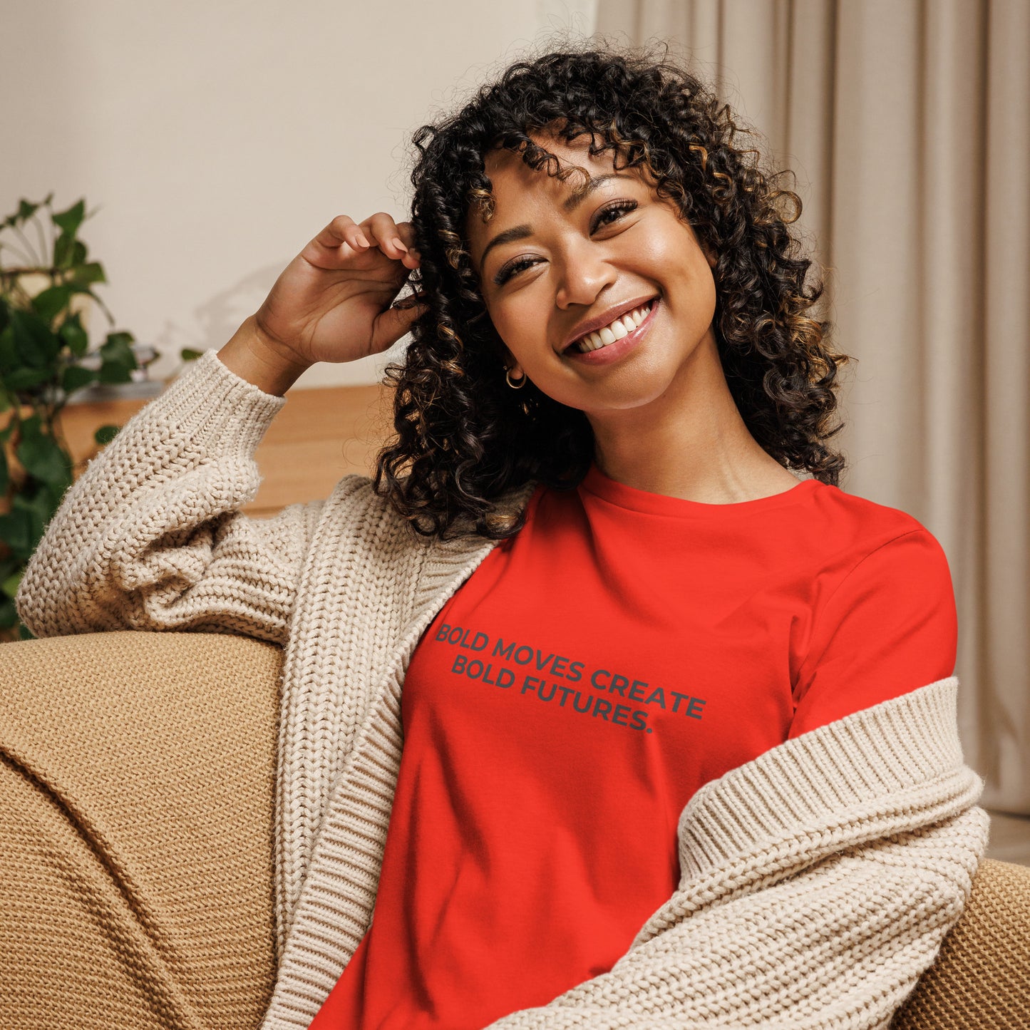 Woman wearing a poppy relaxed tee with "Bold Moves Create Bold Futures" printed, available in various colors and sizes from S-3XL.