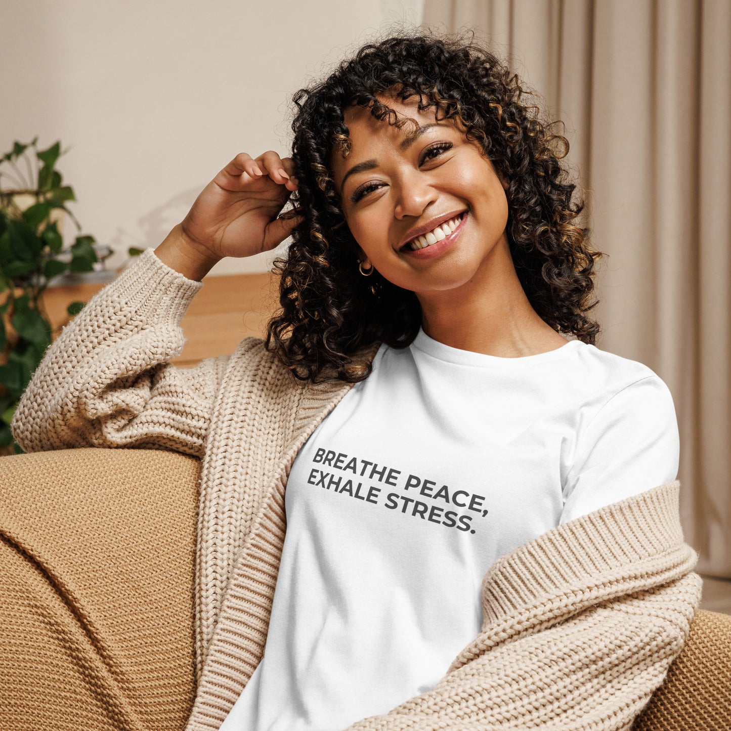 Woman wearing a white relaxed tee with "Breathe Peace, Exhale Stress" printed.