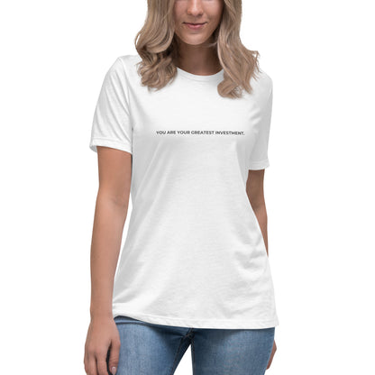 Woman wearing a white relaxed tee with "You Are Your Greatest Investment" printed.