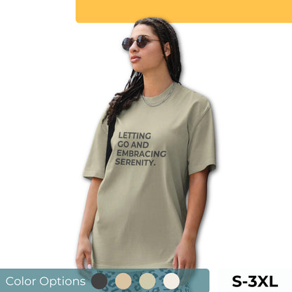 Woman wearing a faded oversized tee in various colors and sizes S-3XL, featuring the phrase "Letting Go and Embracing Serenity."